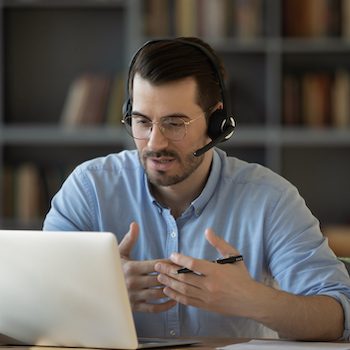 a person wearing a headset while sitting at their computer