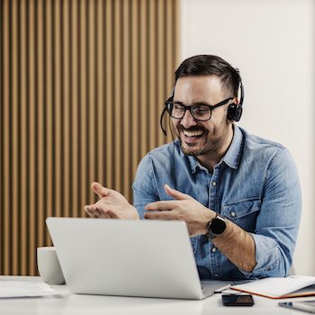 a person working at their computer with a headset on